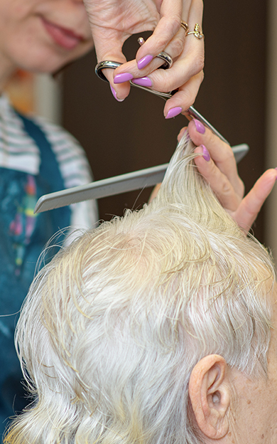hairdresser cutting an elderly woman's hair