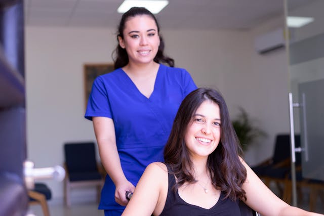 resident in a wheelchair and smiling nurse
