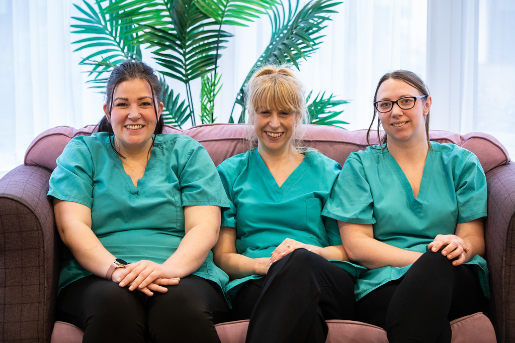 3 care workers in green uniform